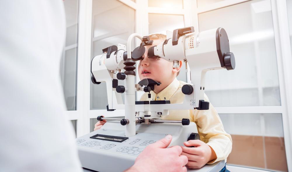 children receiving an eye exam from his optometrist in greenville