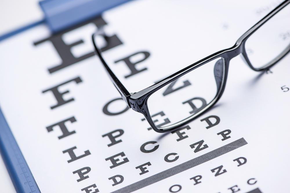 A pair of eye glasses on an eye chart- Knowing What Are The Benefits Of Wearing Eyeglasses In Pensacola - Fifty Dollar Eye Guy 5328 N Davis Hwy Pensacola, FL 32503 (850) 434-6387 .jpg