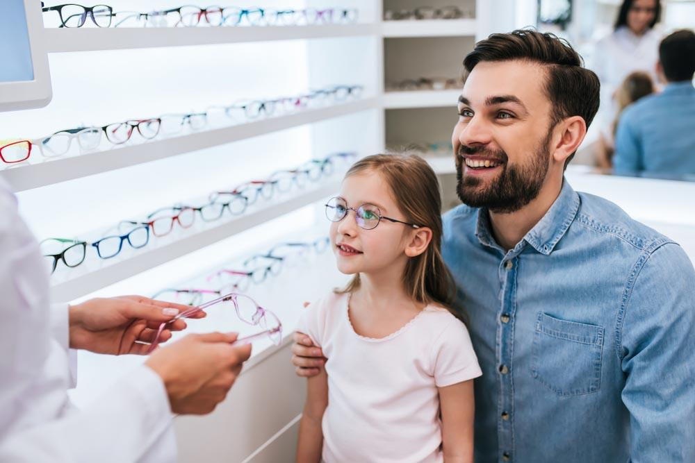 a child with father getting eye glasses from eye doctor- Guide To Choosing The Right Reading Glasses For You In Pensacola - Fifty Dollar Eye Guy 5328 N Davis Hwy Pensacola, FL 32503 (850) 434-6387 .jpg