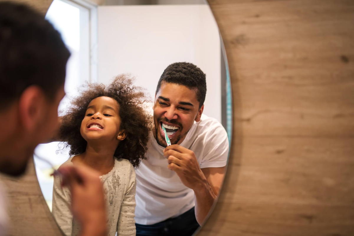 father and daughter brushing teeth after visiting Commack pediatrics specialist