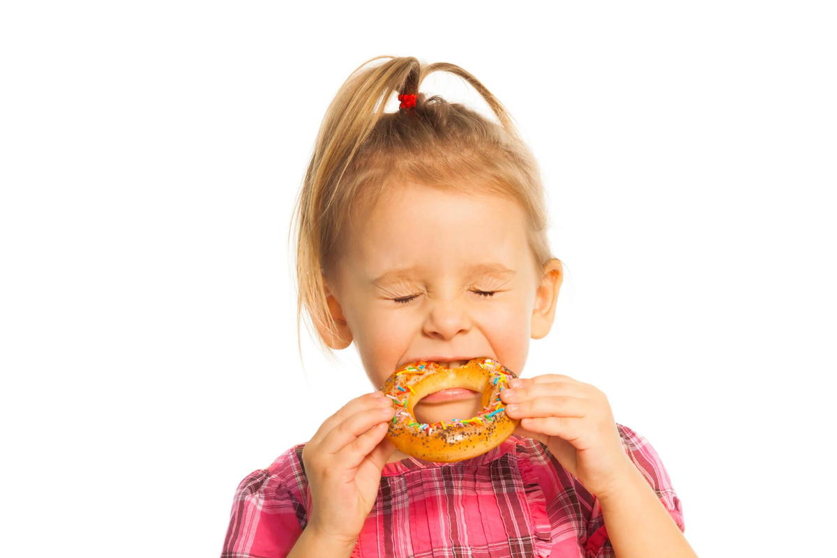 kid eating donut before seing dentist for Suffolk pediatrics