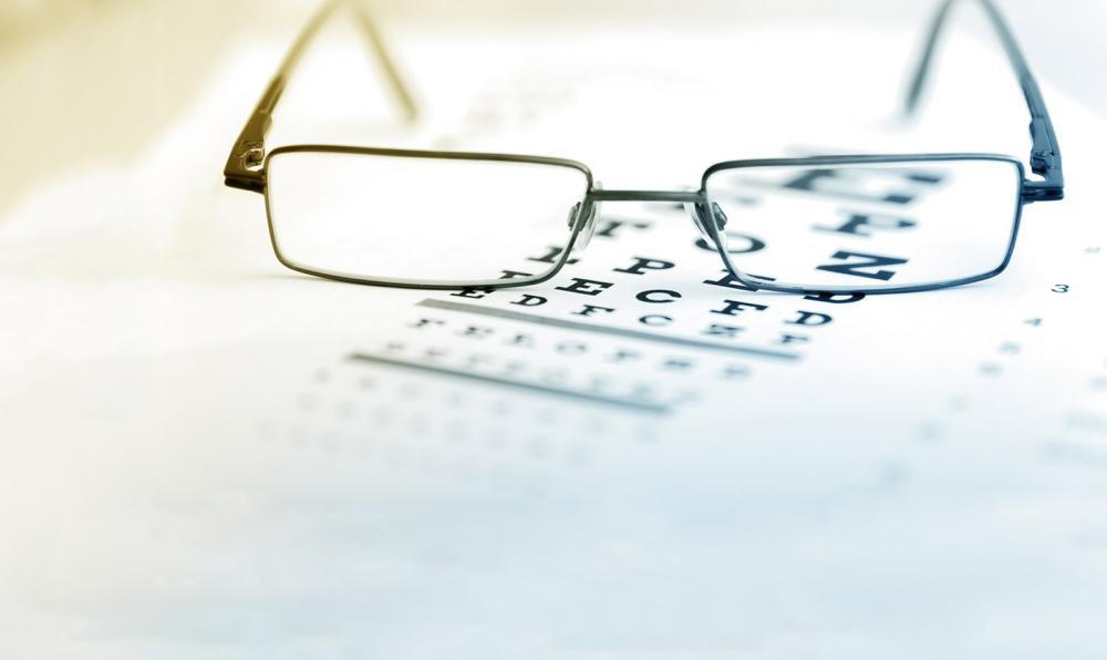 A pair of glasses sitting on a vision chart.