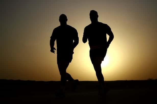 What causes shin splints with image of two runners at sunset