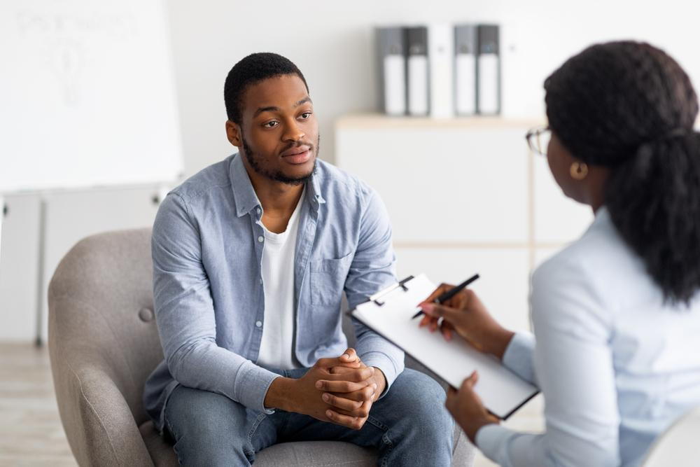 Adult sitting with provider talking in a therapy session