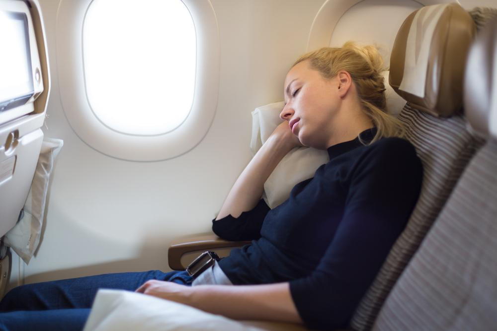 Woman resting on an airplane.