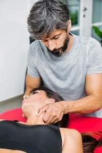 chiropractor massaging patient from the neck for headache treatment | chiropractic care for headaches and migraines