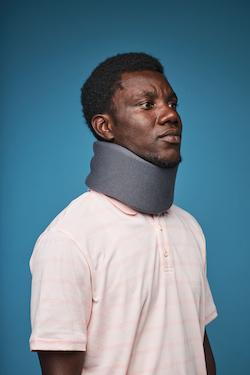 injury treatment for man with whiplash wearing a neck brace
