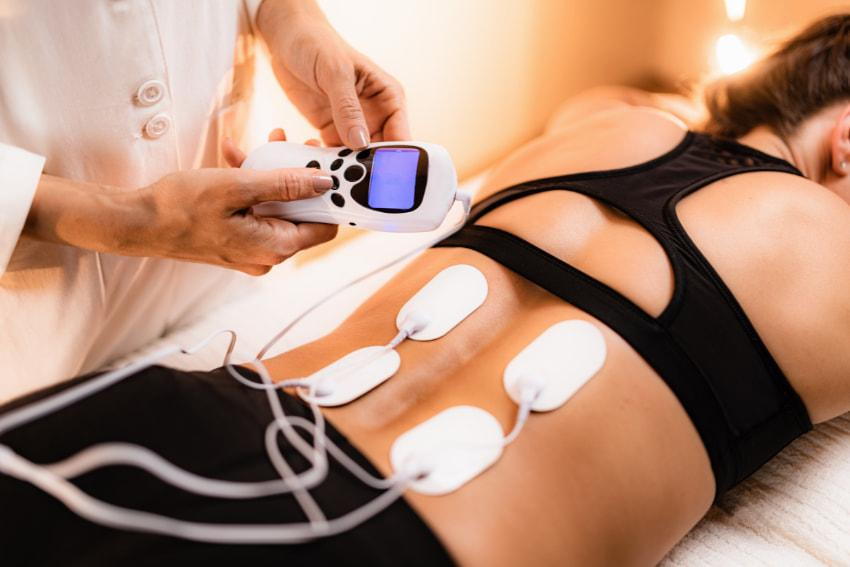 Woman having some electric stimulation treatment with chiropractic techniques for sciatica