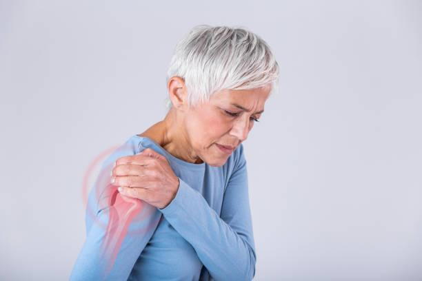 Old woman feeling of intense pain caused by shoulder pain.
