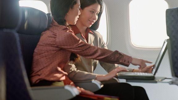 business-woman-using-laptop-airplaine.jpg?u=at8tiu&use=idsla&k=c