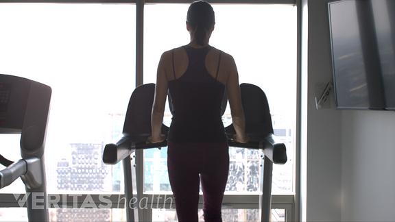 Image of woman walking on the treadmill to relieve back pain