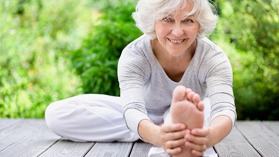 Image of a senior woman doing a hamstring stretch for sciatic pain
