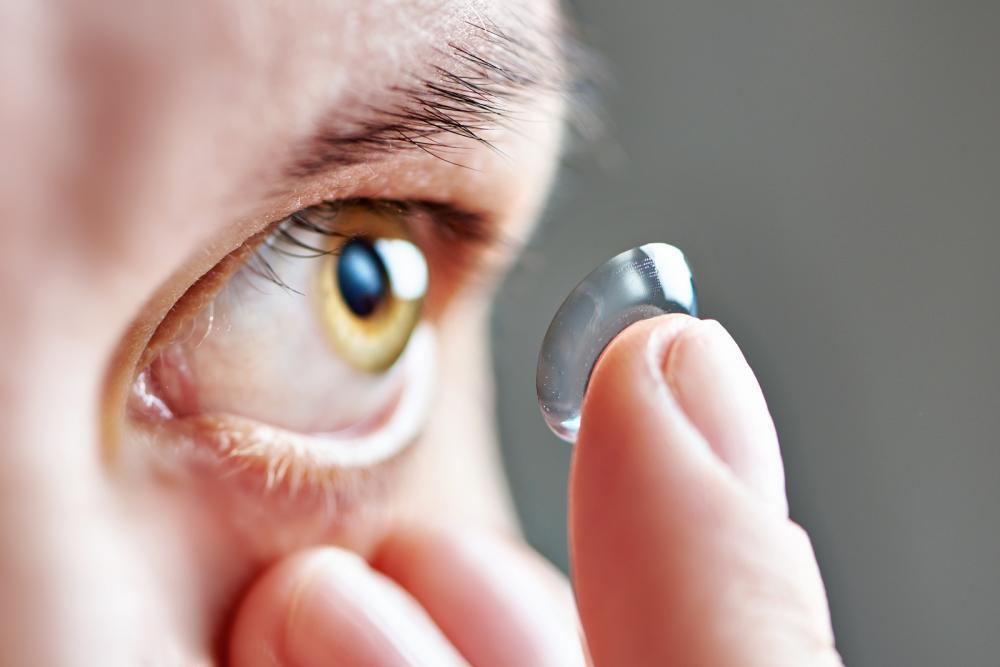 man putting specialty contact for dry eye into eye from lancaster optometrist