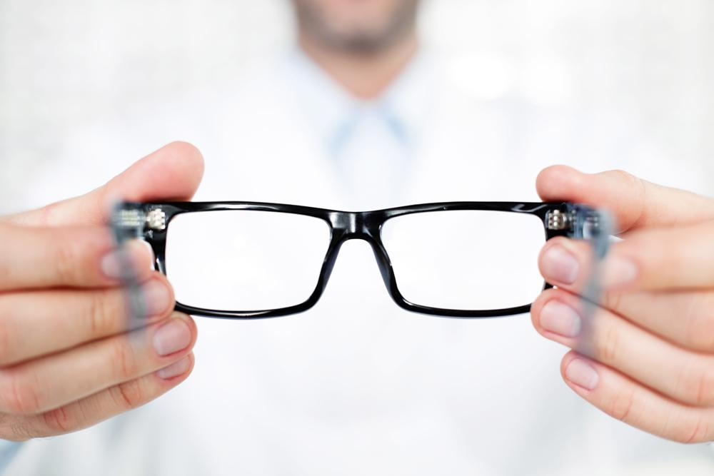 Optometrist holding out eyeglasses